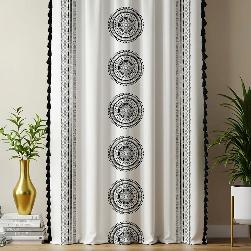 Front view of black and white curtain with tasseled sides and geometric circular pattern