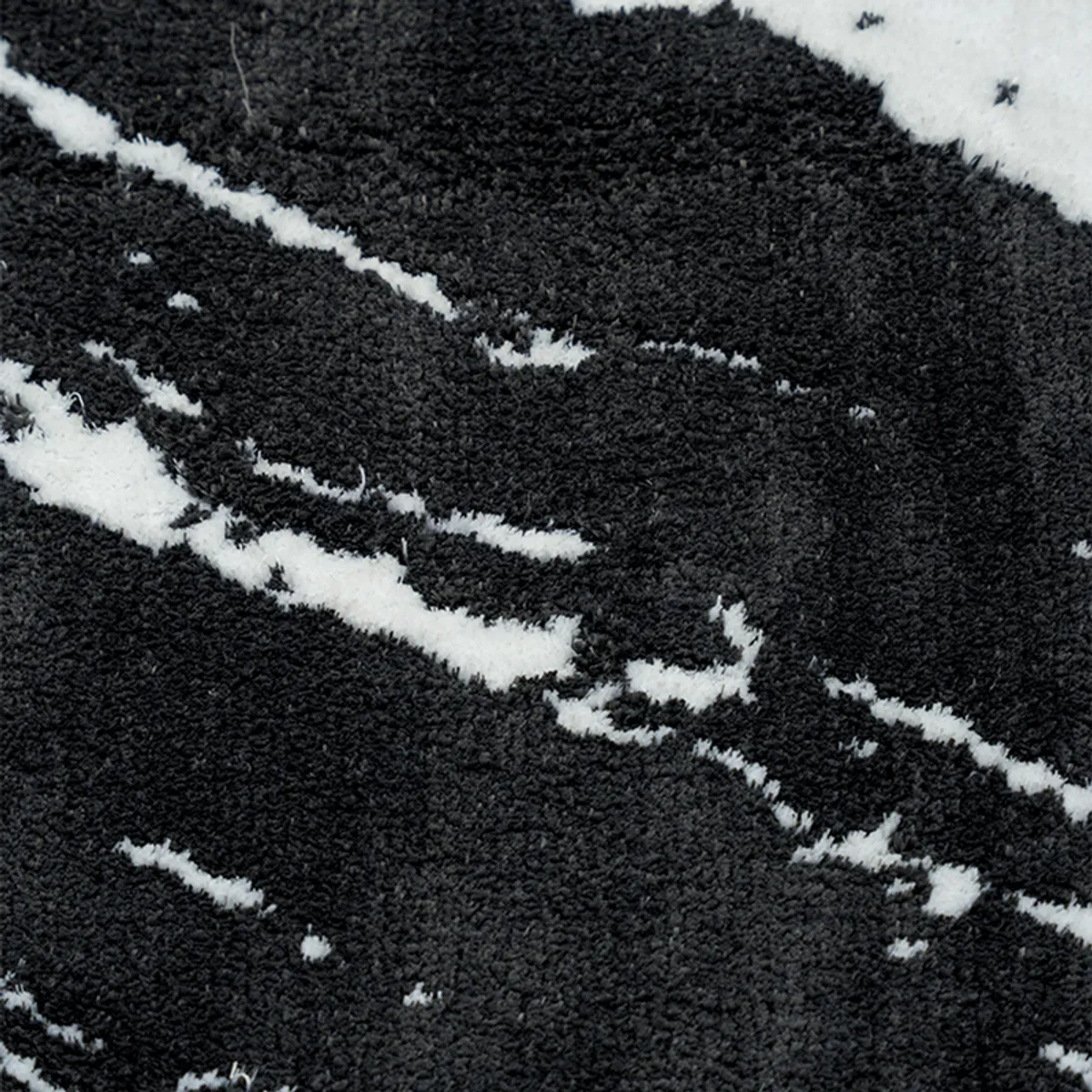 Close-up of the plush black and white marble-patterned bath mat surface