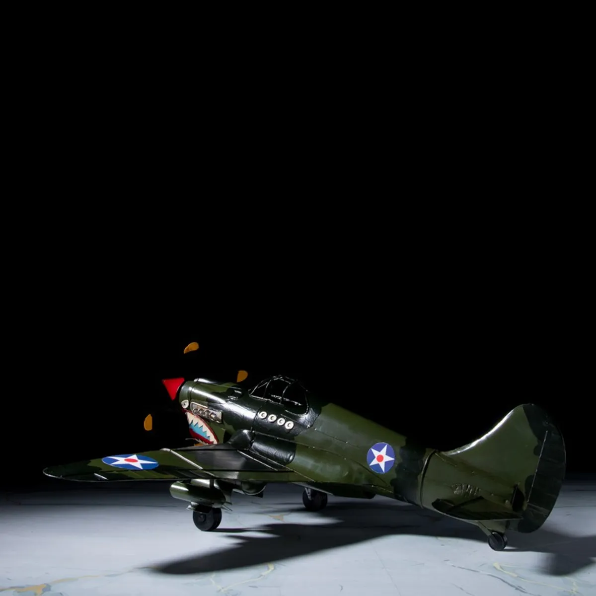 Rear angled view of iron fighter jet showpiece against a dark backdrop