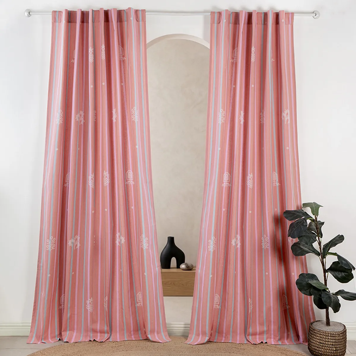 Pair of pink striped curtains hanging on a rod in a bright room