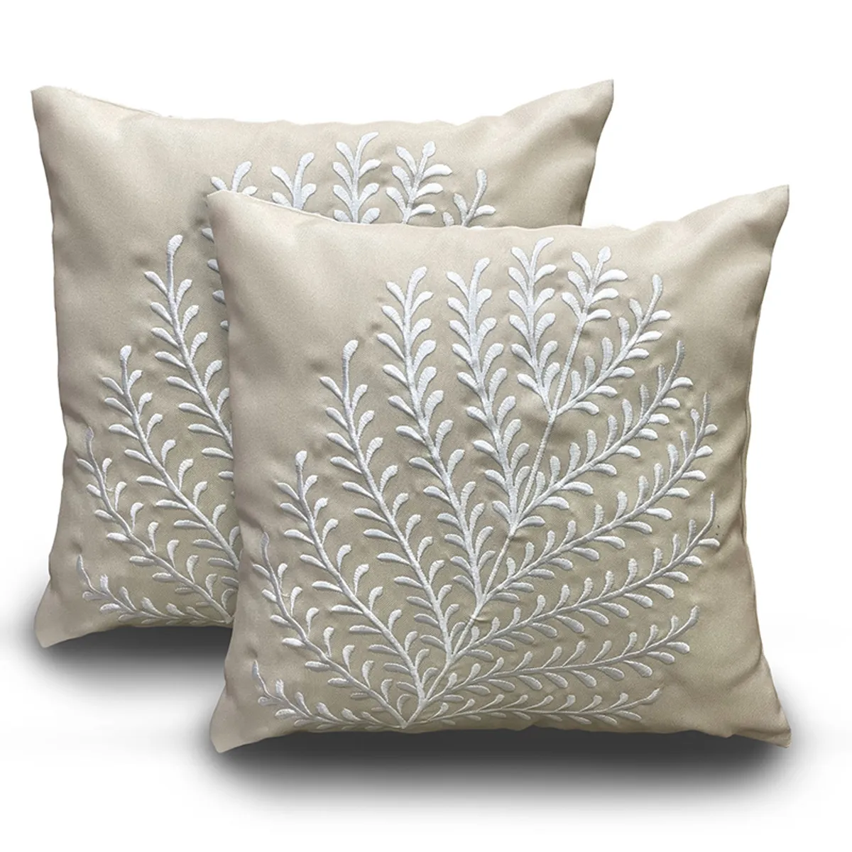 Two beige embroidered cushion covers with white leafy motifs on a white background