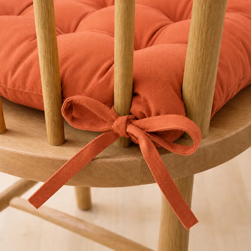 Close-up of terracotta brown chair pad tie fastened to a wooden chair