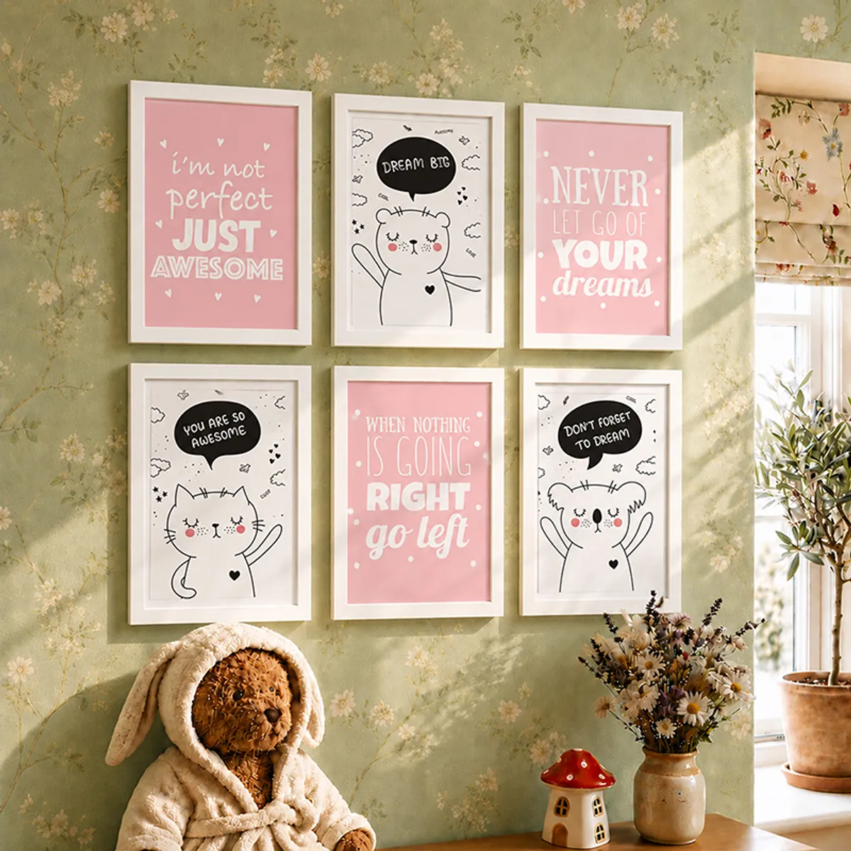 Six white-framed pink and black wall art prints styled on a floral green wall near a window.