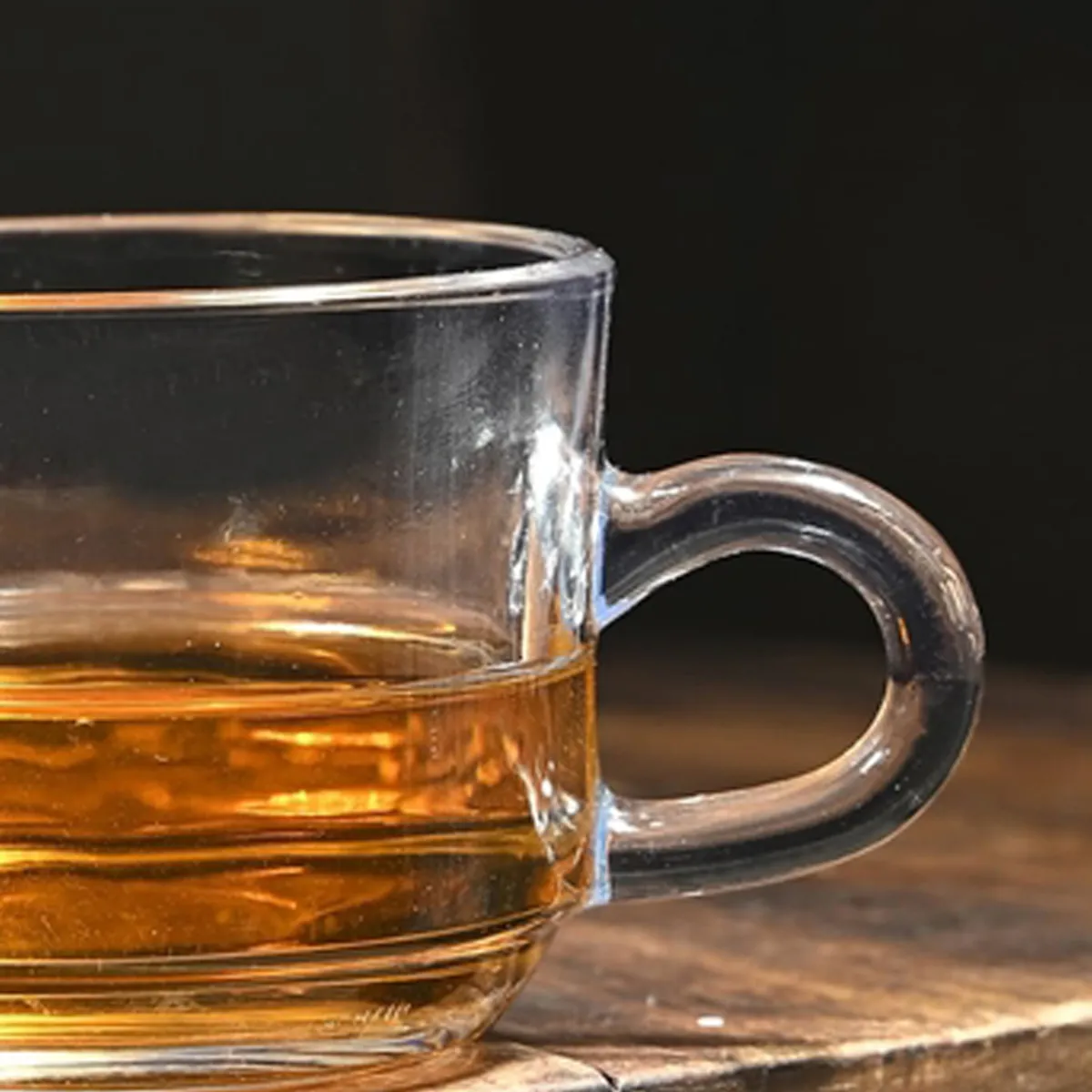 Close-up of a clear glass tea cup filled with amber tea