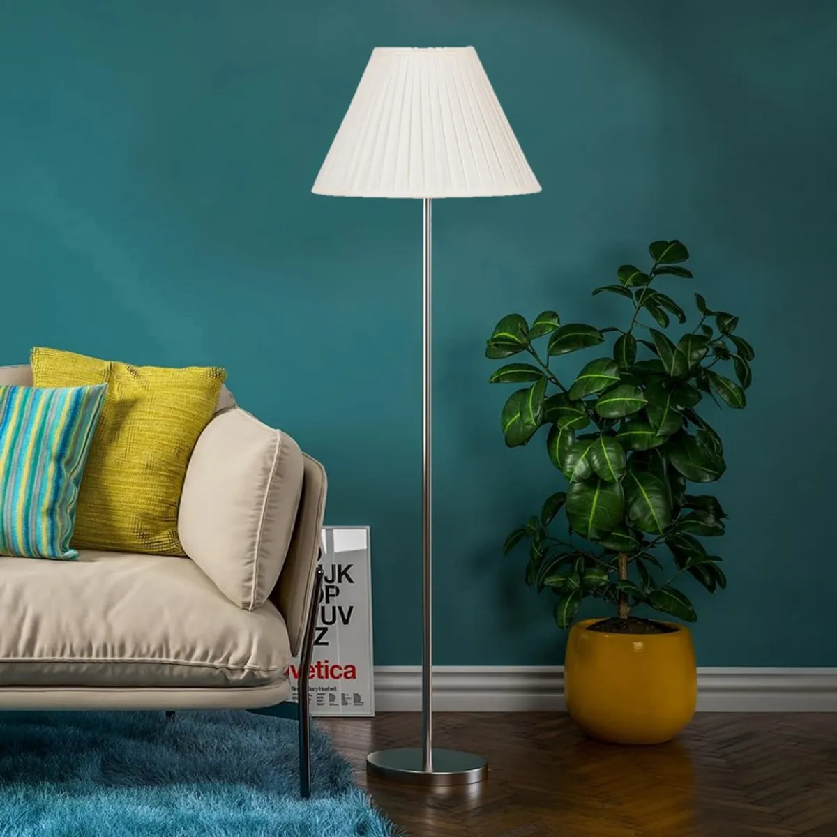 White pleated floor lamp beside a cream sofa and potted plant against a teal wall