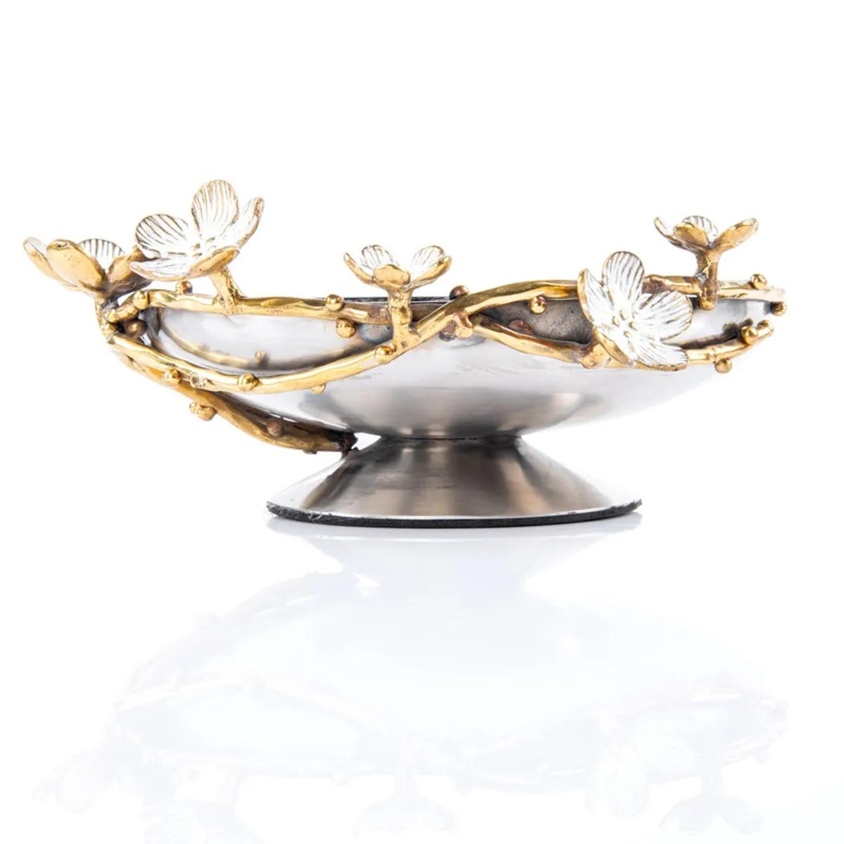 Side view of a silver bowl with a raised base and gold floral rim