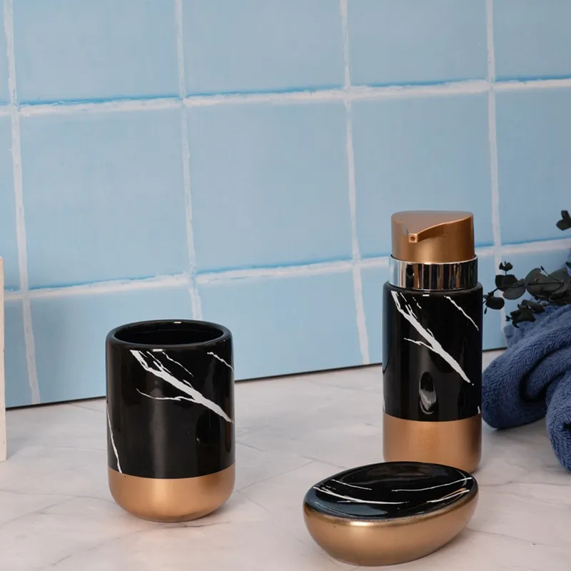 Three-piece black and gold bathroom set styled on a blue-tiled counter