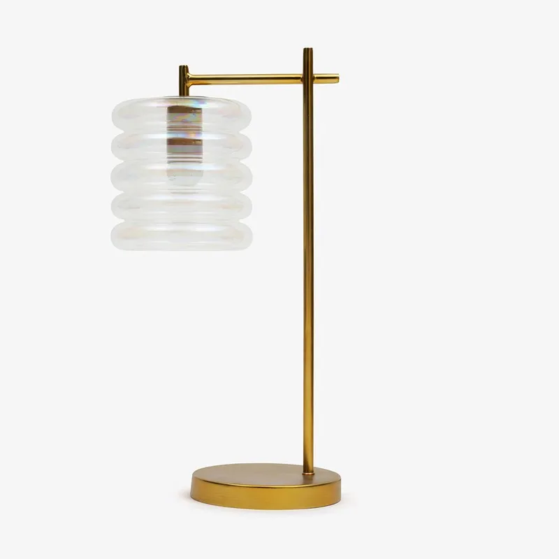 Studio view of transparent ribbed glass table lamp with gold-toned metal base