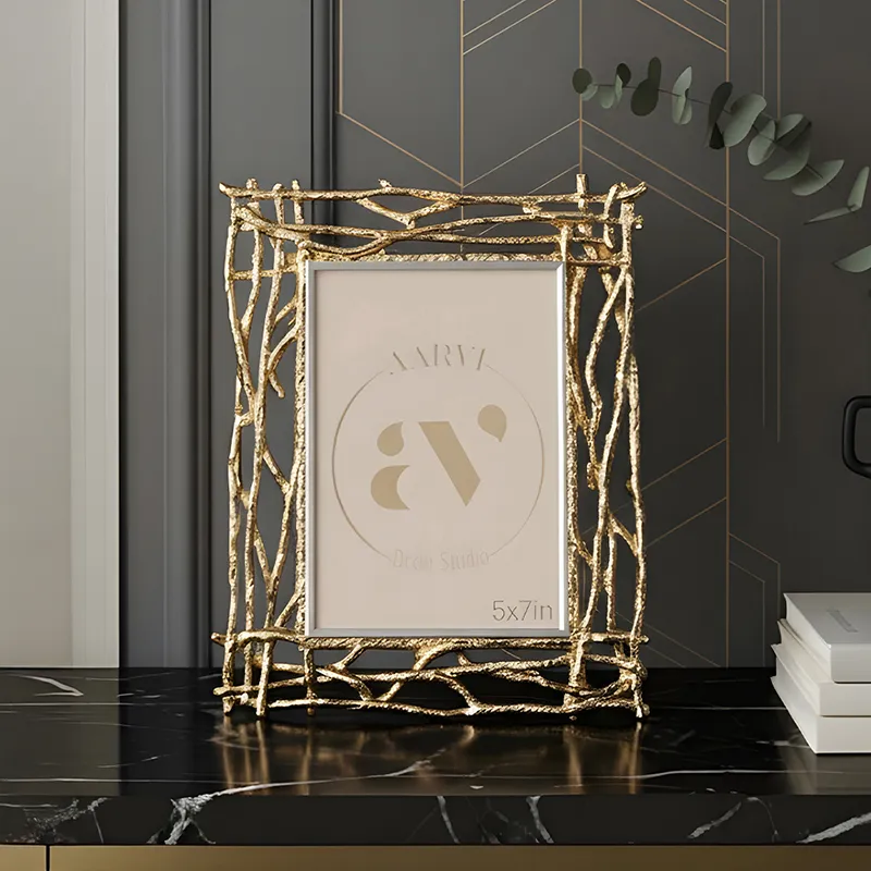 Gold branch-style rectangular photo frame displayed on a dark tabletop