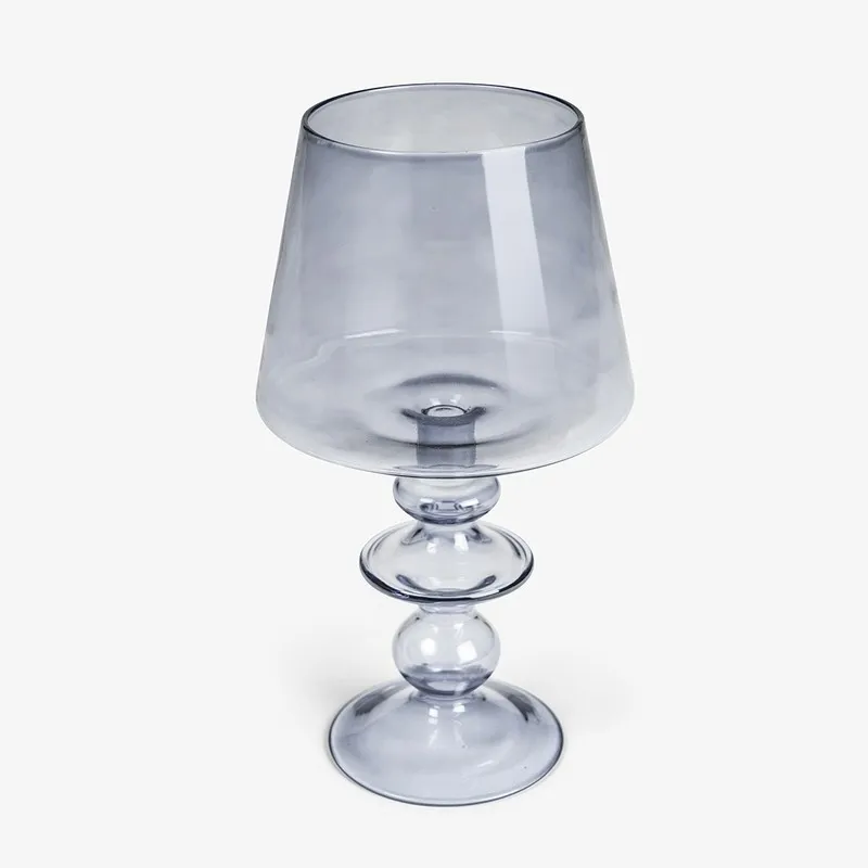 Grey glass candle holder shown on a plain background