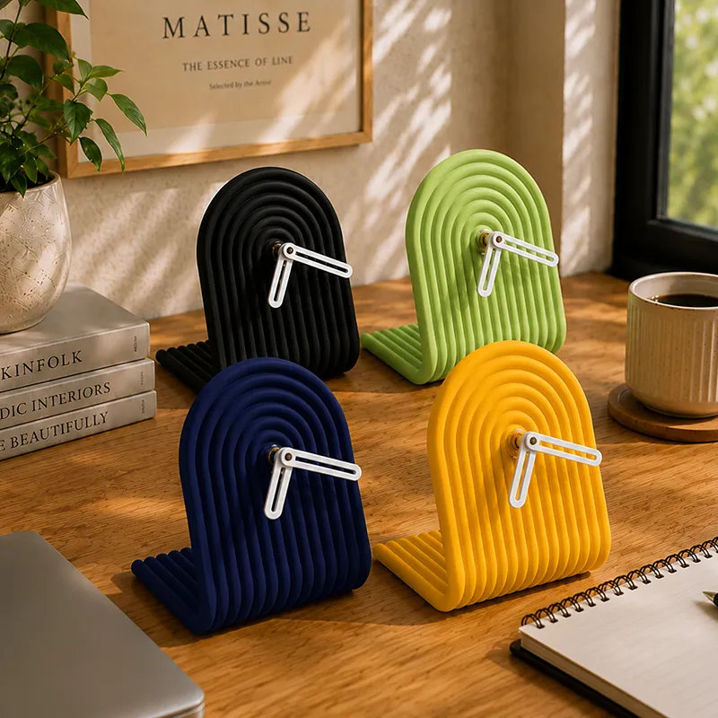 Four arched ribbed table clocks in black, green, blue and yellow on a desk