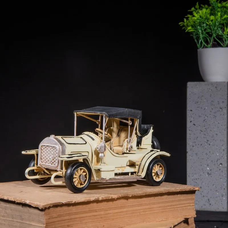 Light yellow retro vehicle showpiece displayed on stacked books