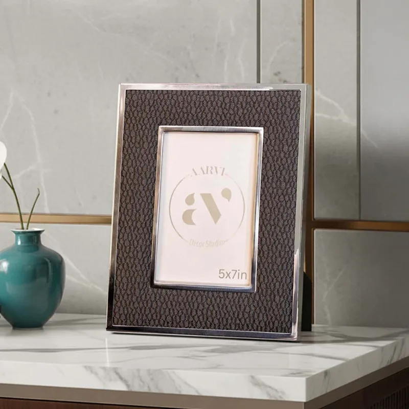 Black rectangular photo frame with textured fabric finish and metallic border on a tabletop