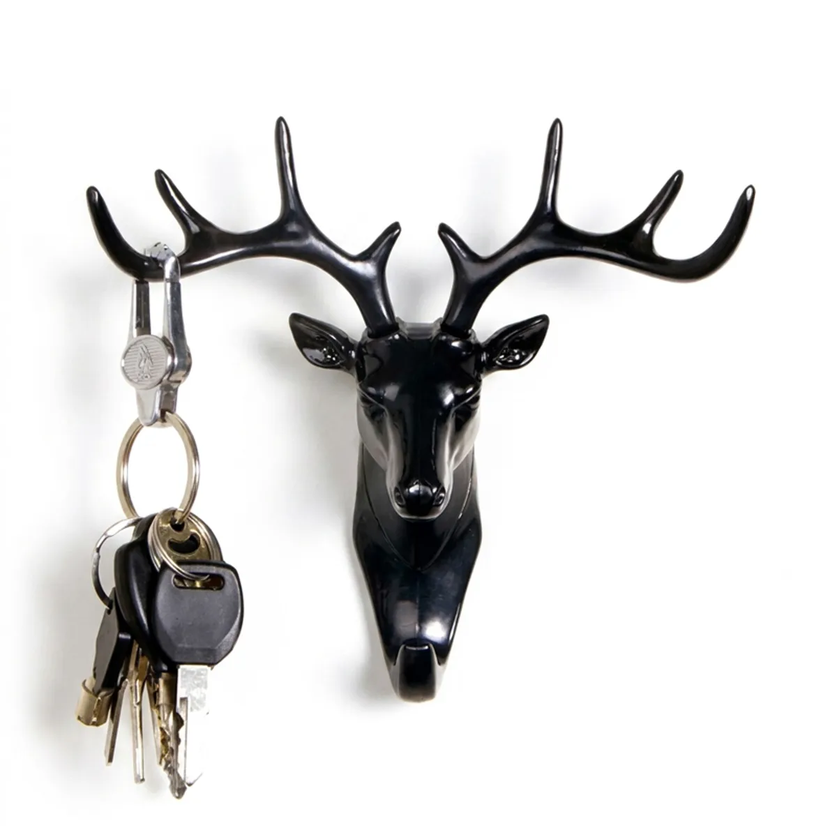 Black deer antler wall hook holding a set of keys on a white background
