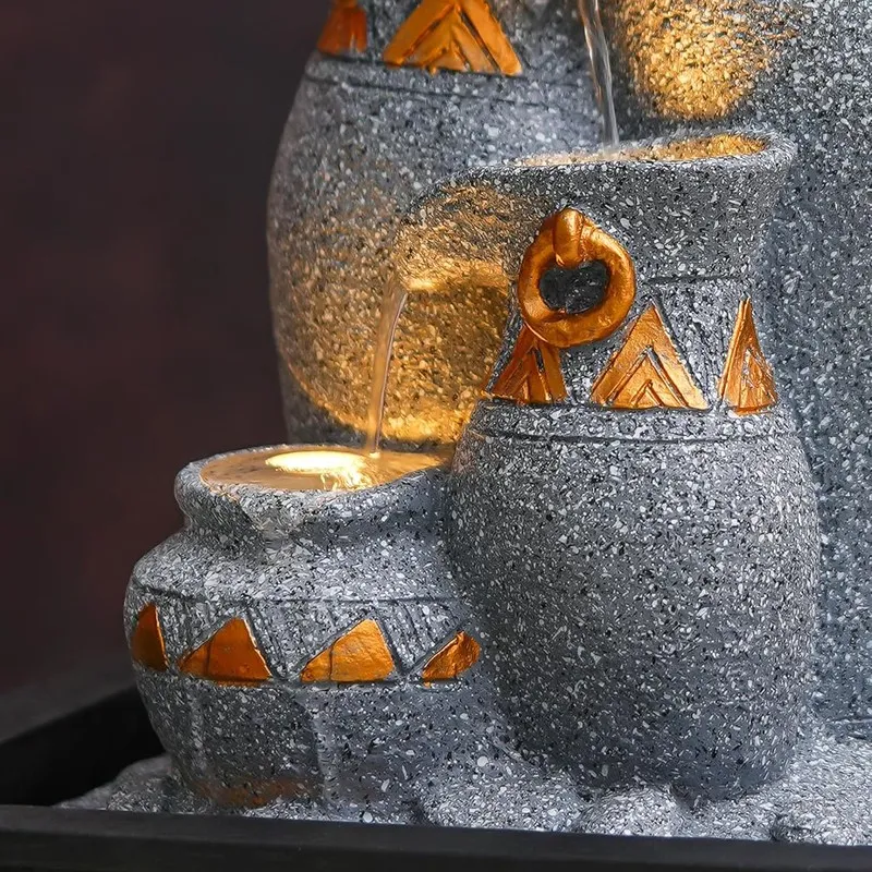 Close-up of the lower bowls and warm LED light in the textured fountain.