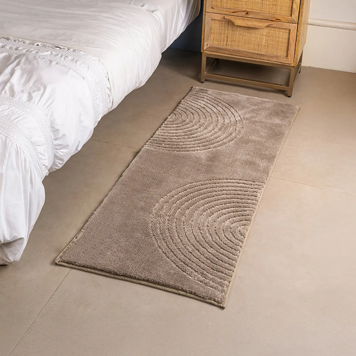 Beige geometric arc runner rug placed beside a bed in a contemporary bedroom.
