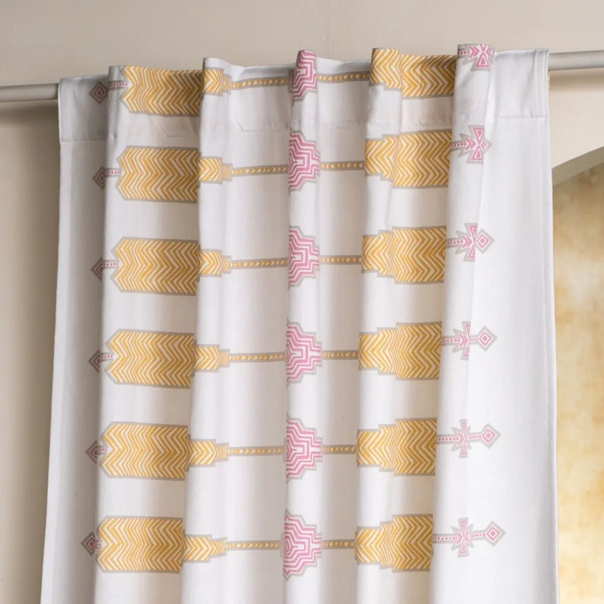 White curtain with back tabs hanging from a rod