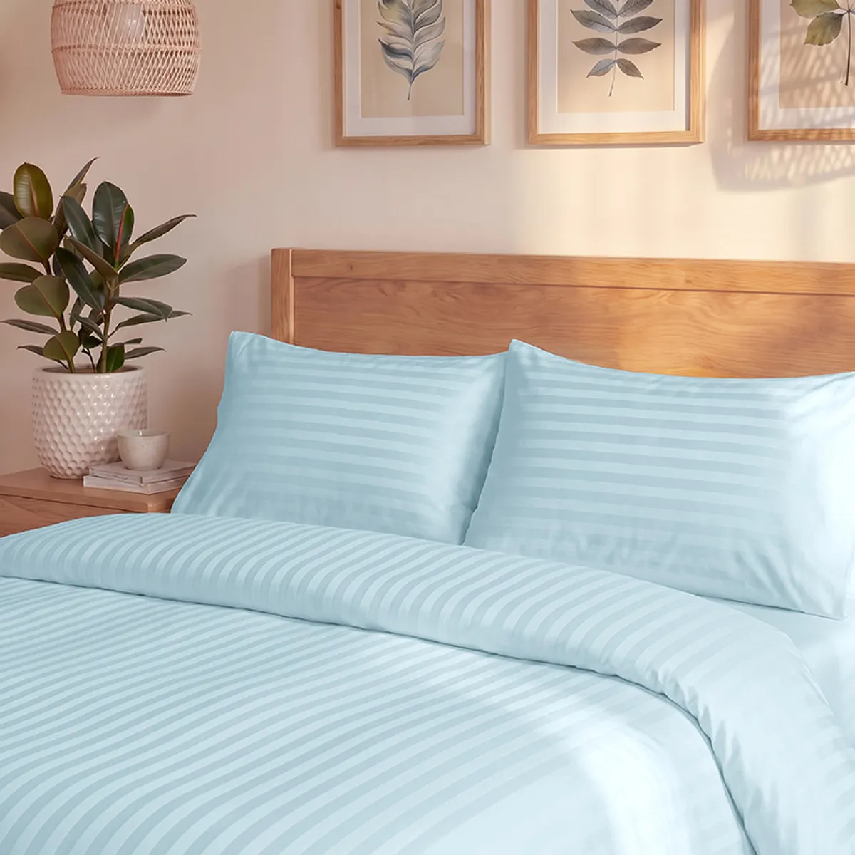 Close view of pale blue striped duvet cover and matching pillows on a bed