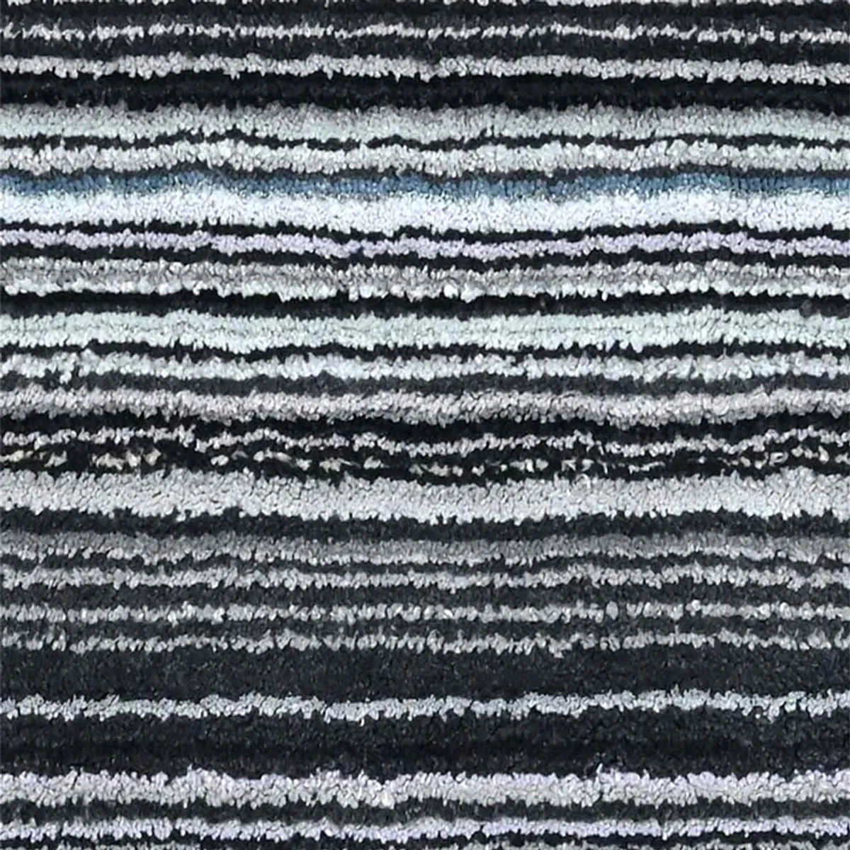 Close-up view of the carpet's grey, black and white striped pile