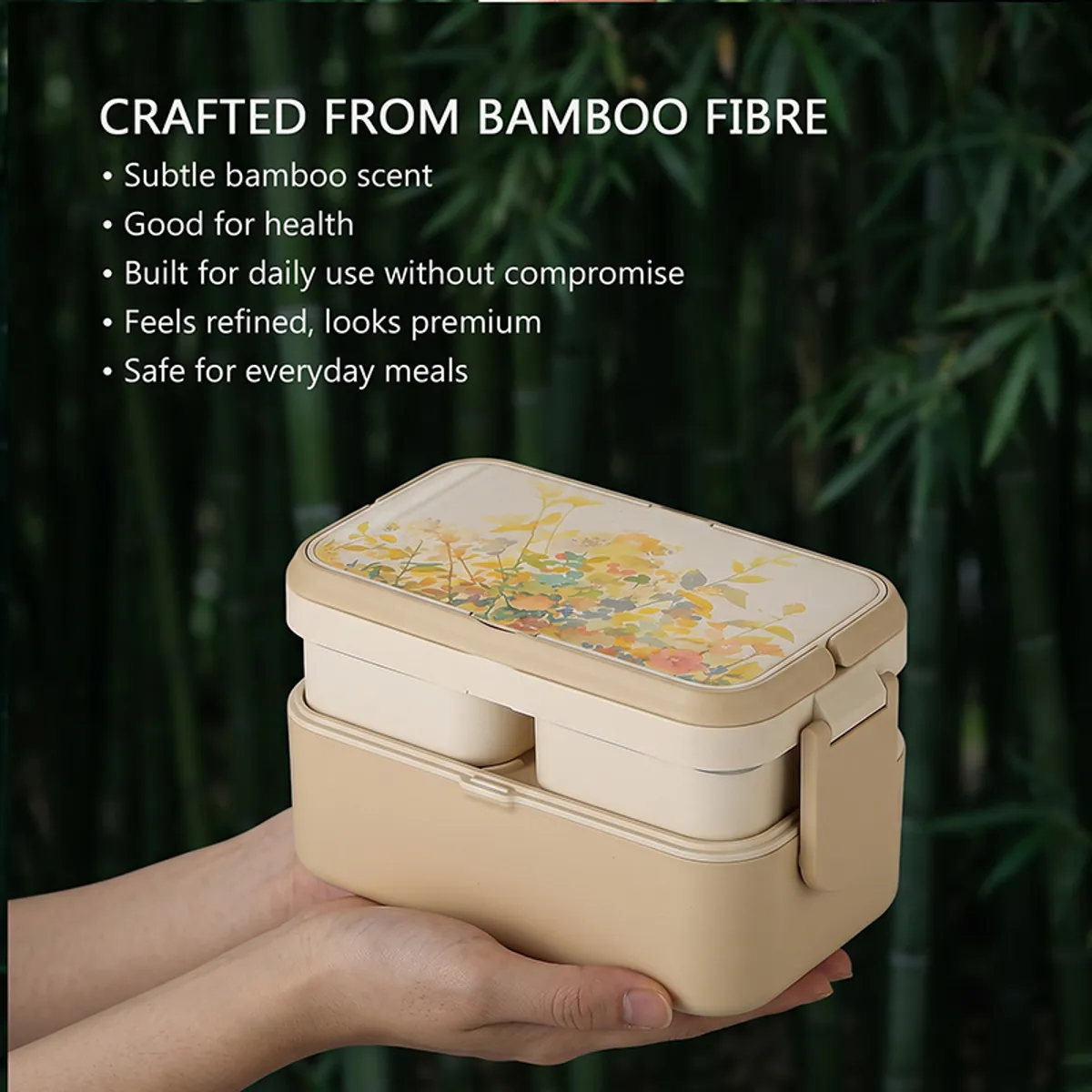 Beige floral lunch box held in hands against a leafy green background.