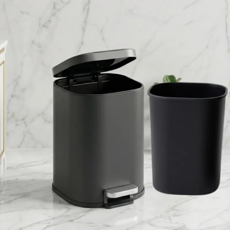 Black pedal dustbin with removable inner bucket placed beside it