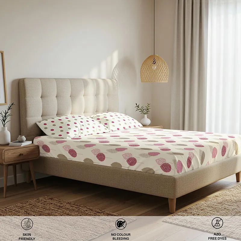 Angled view of pink printed fitted bedsheet styled in a bright bedroom