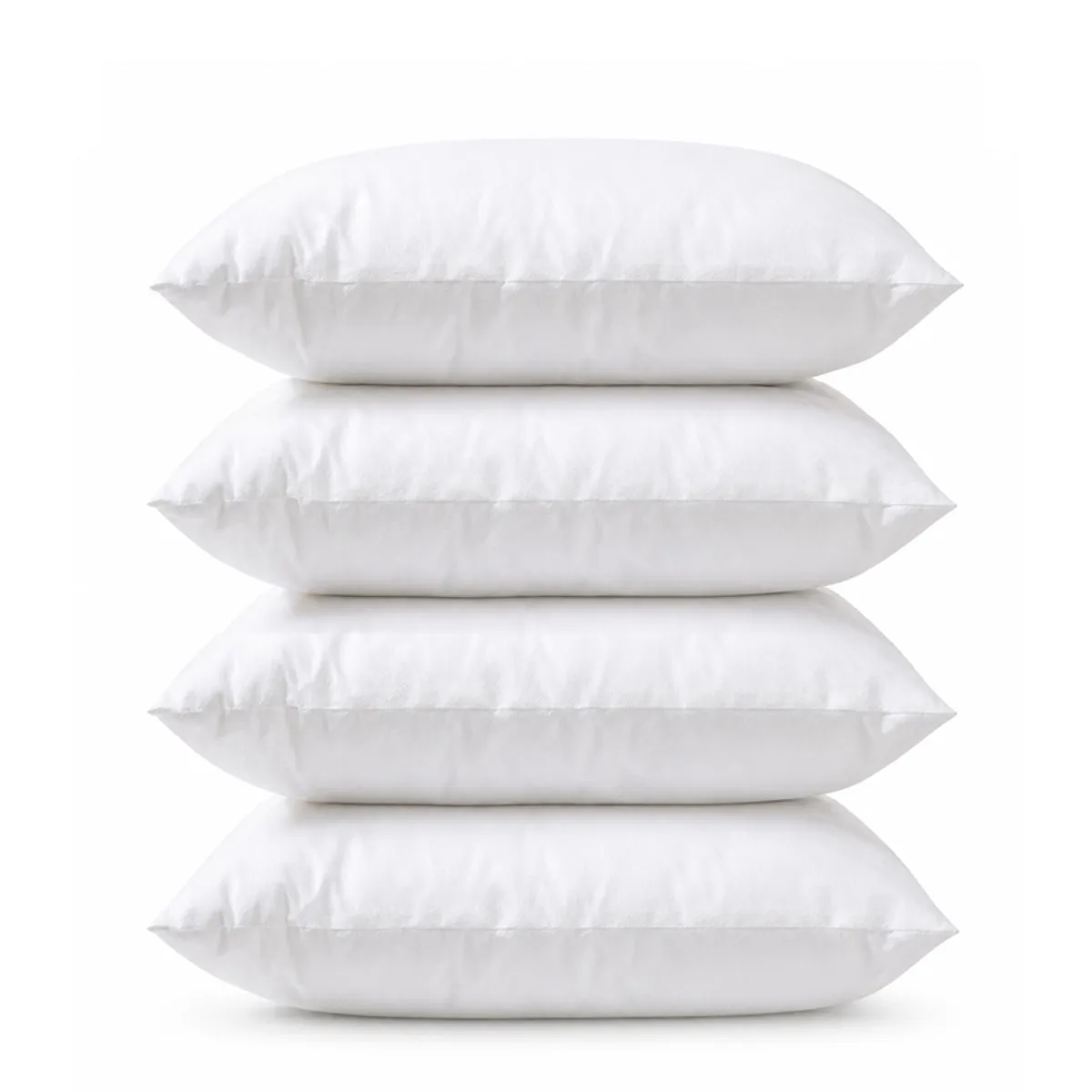 Four white rectangular pillow fillers stacked against a plain white background.