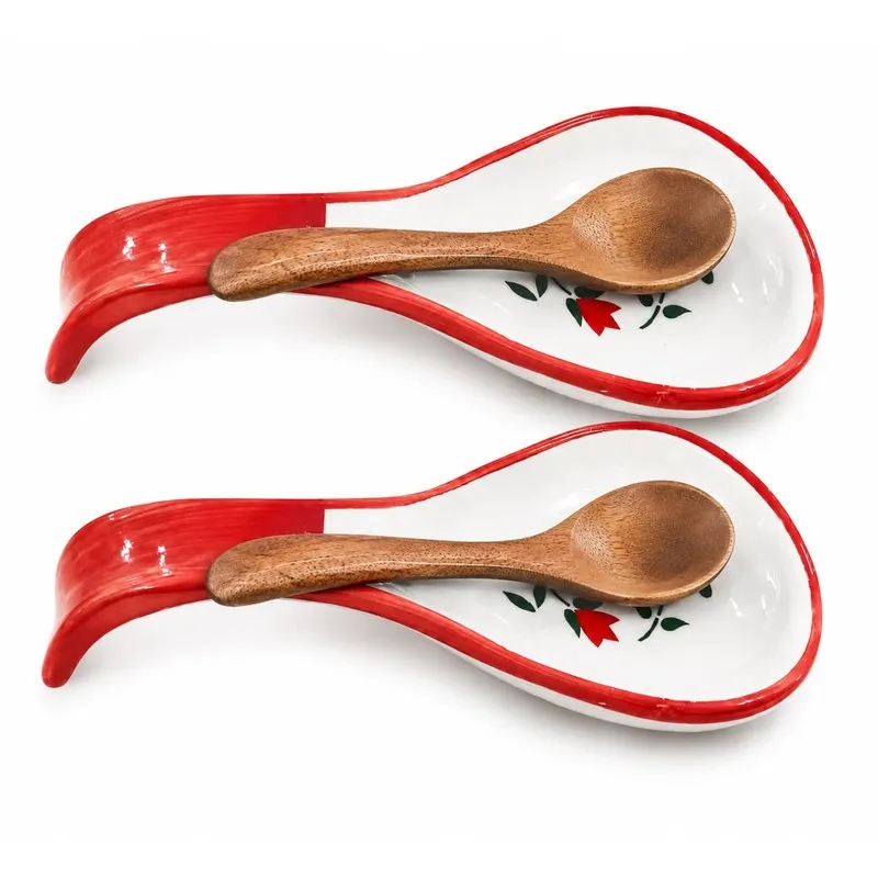 Two floral ceramic spoon rests displayed with wooden spoons on a white background