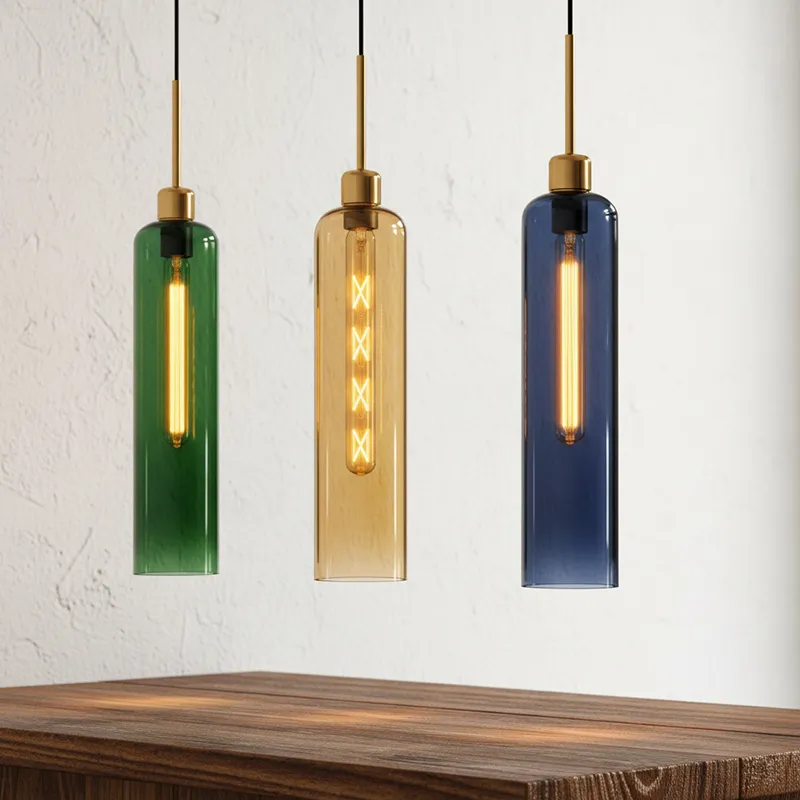 Close-up of three coloured tubular glass pendant lights with gold fittings above a wooden table