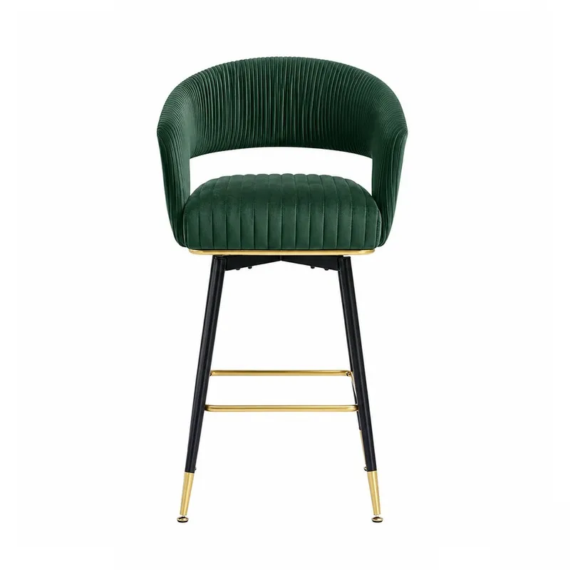 Front view of a green velvet bar stool with a curved back and gold footrest.