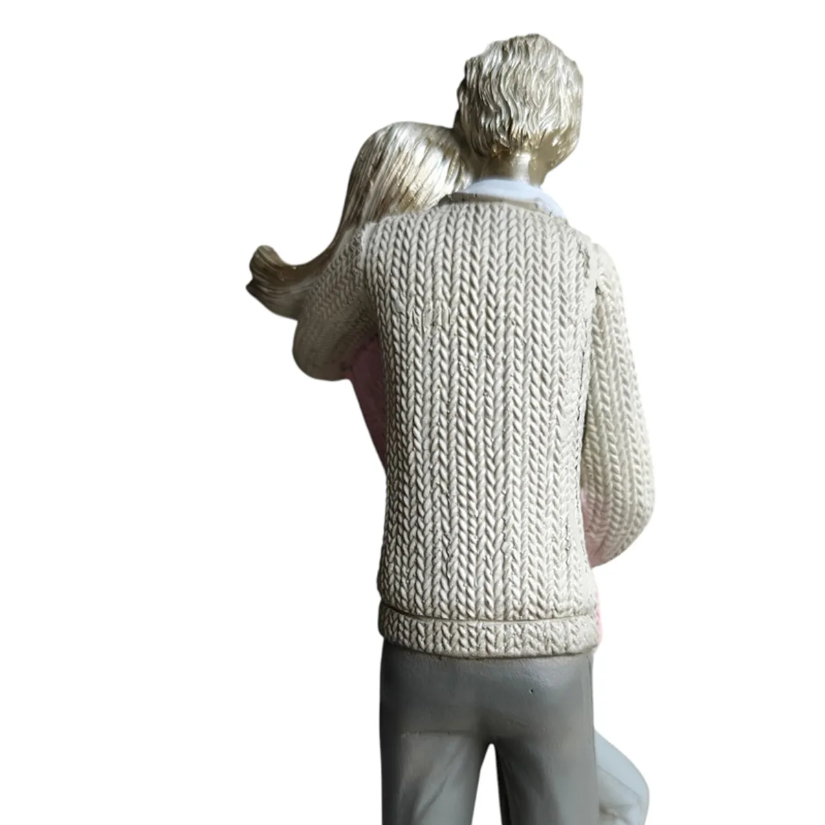 Back view showing textured clothing and intertwined couple figurine