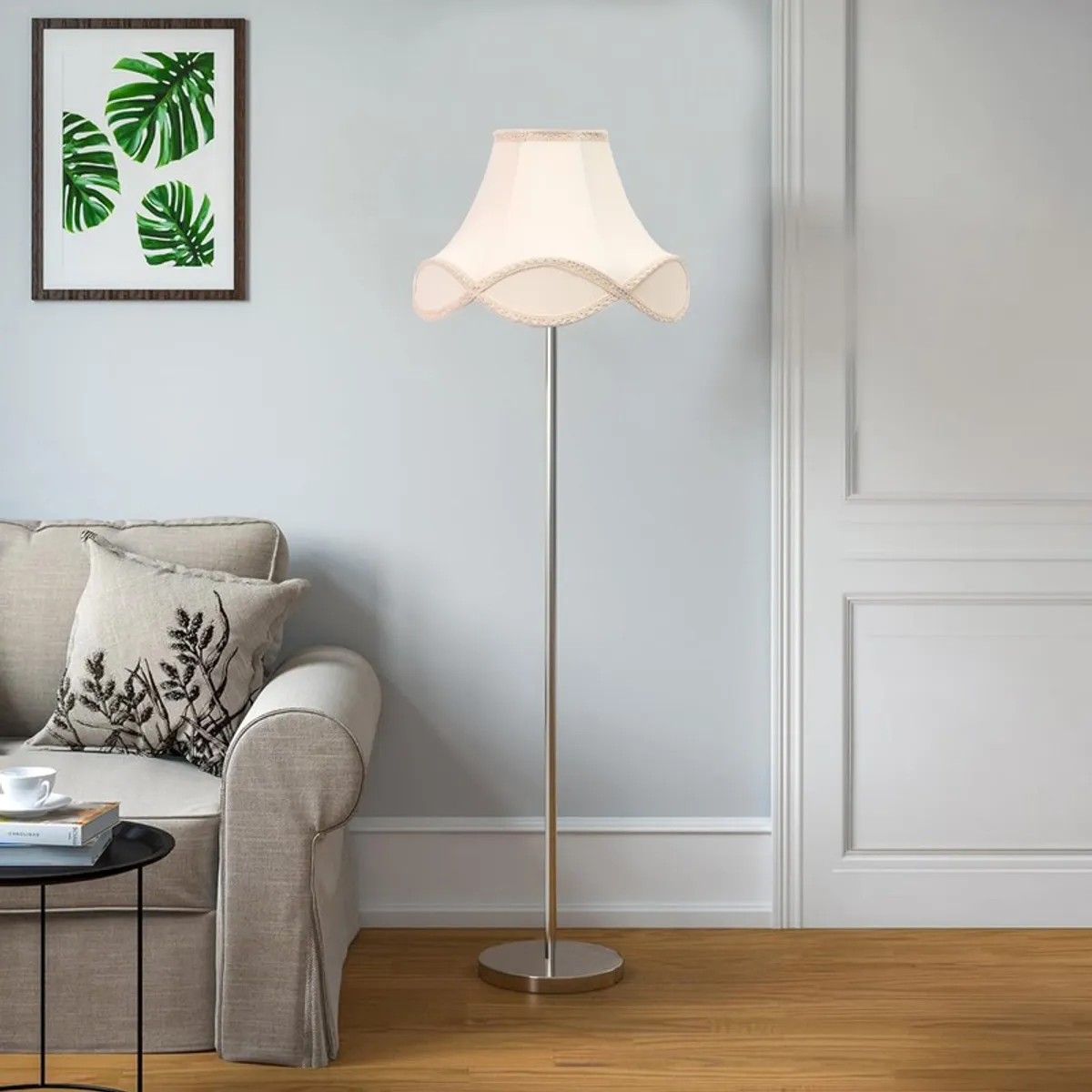 Ivory wave floor lamp shown beside a sofa against a pale wall