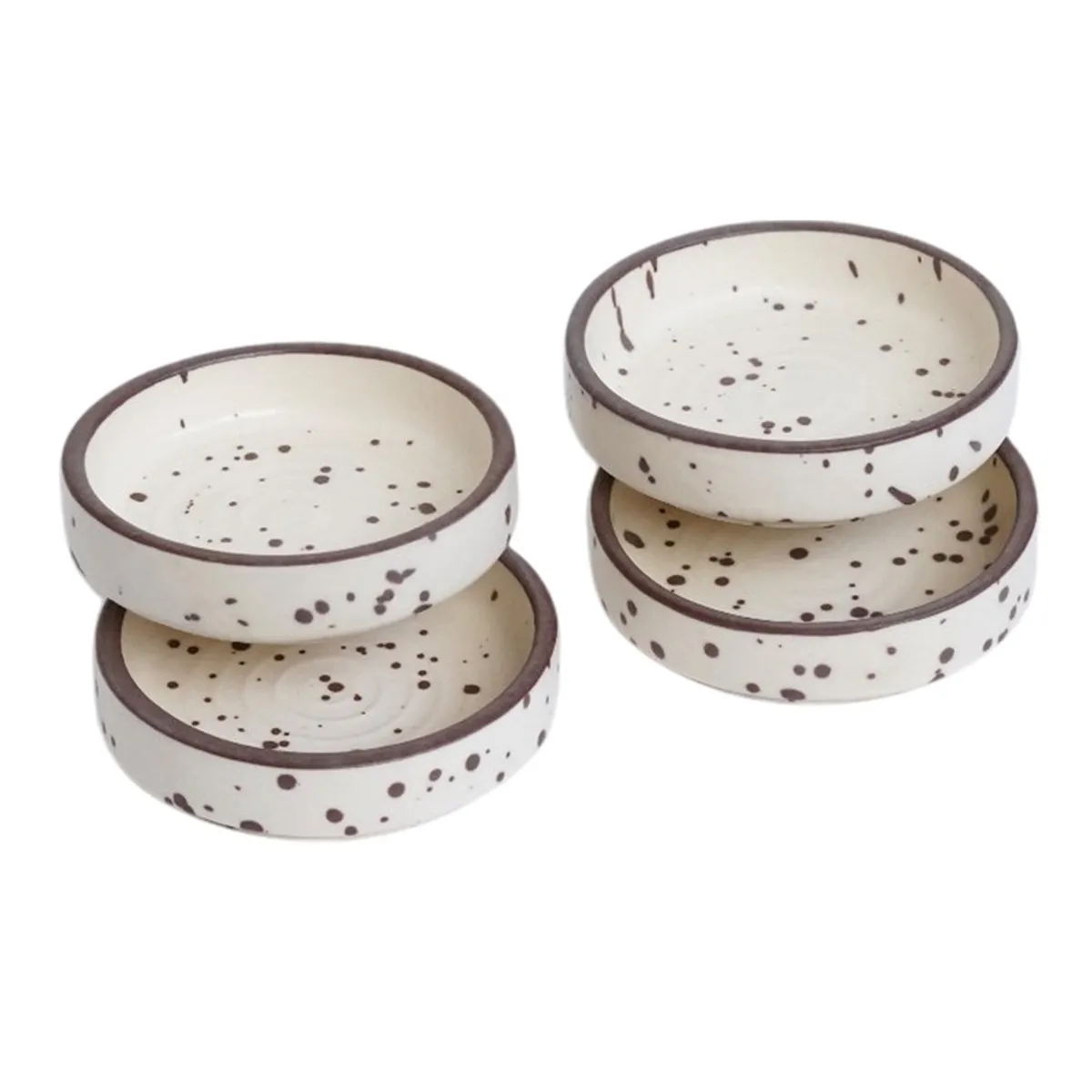 Stacked speckled white ceramic dip bowls with brown rims on a white background