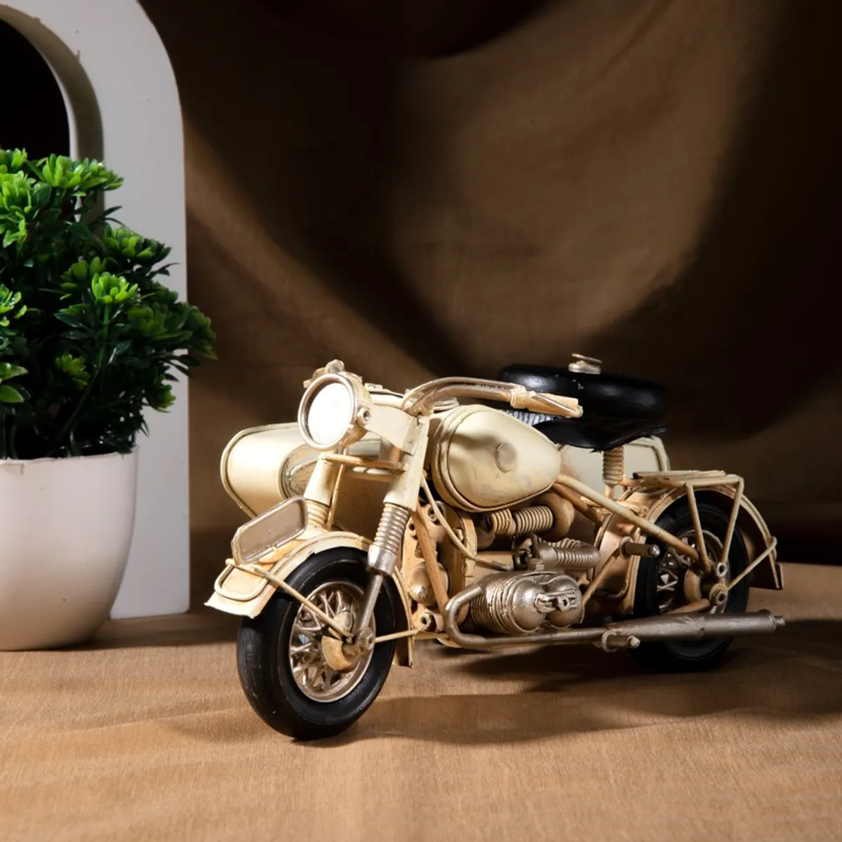 Front angled view of gold-toned sidecar motorcycle showpiece