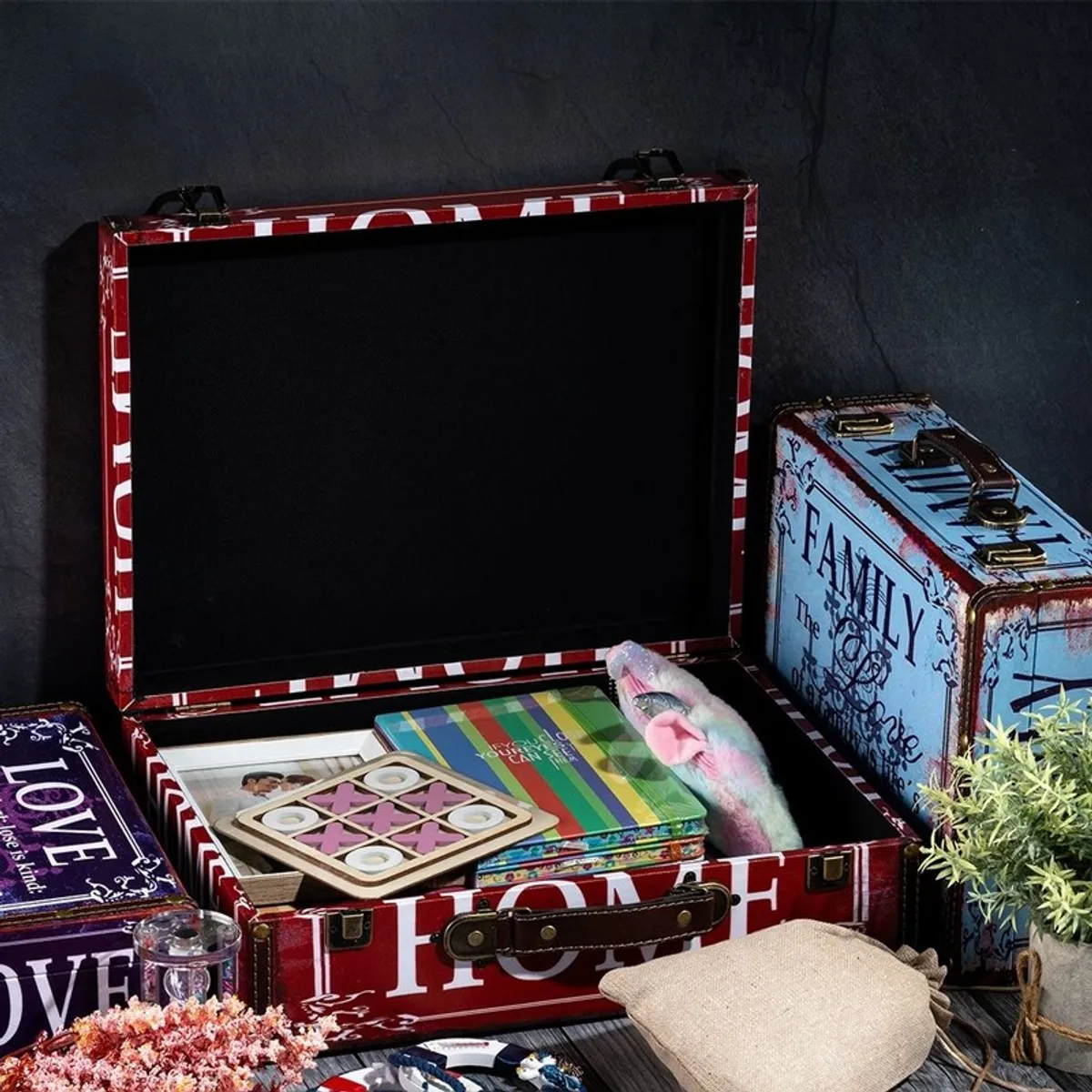 Open vintage storage trunk showing a black interior and red-and-white printed exterior
