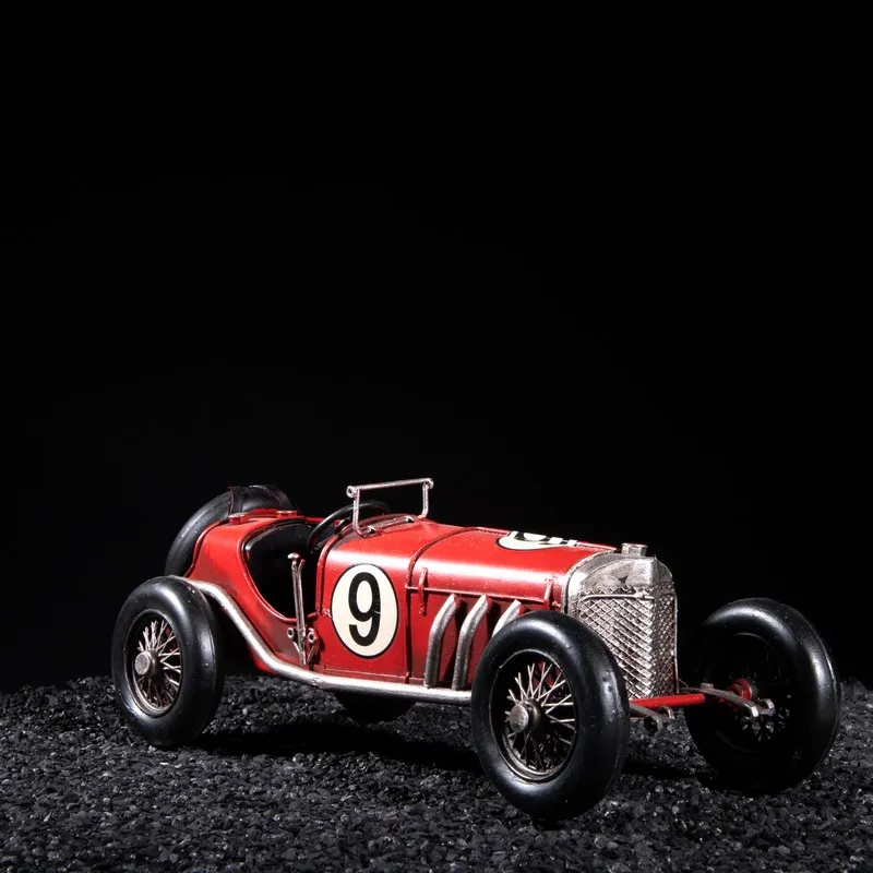 Red vintage race car showpiece with black wheels on a dark backdrop