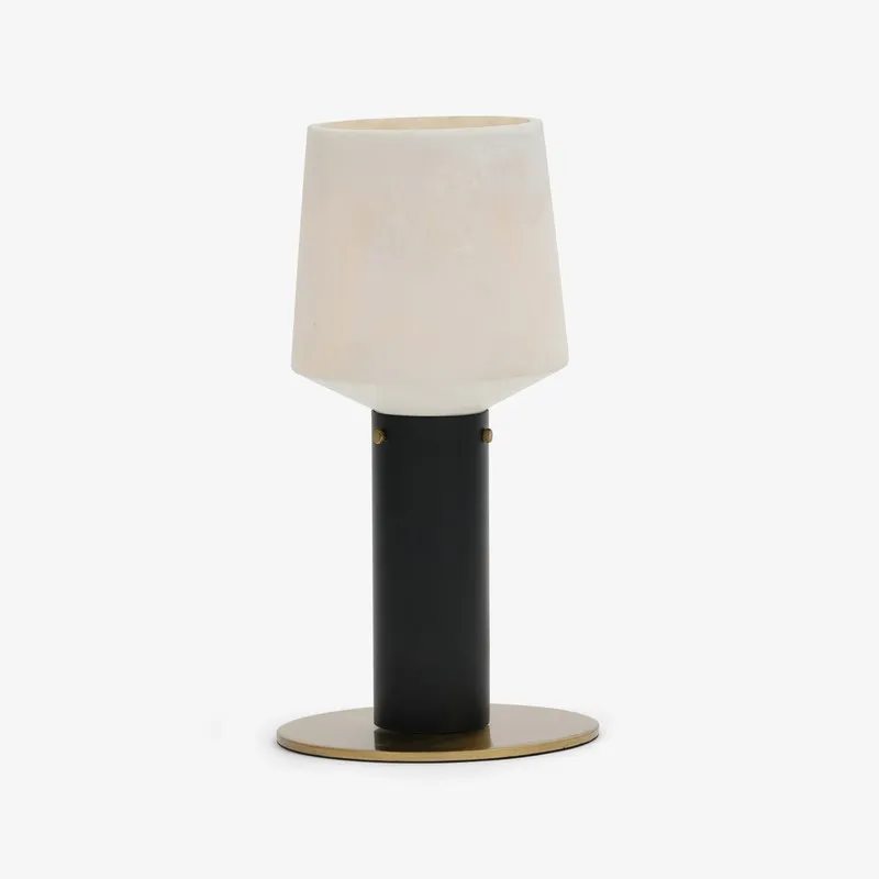 Studio view of black and off-white table lamp with round base