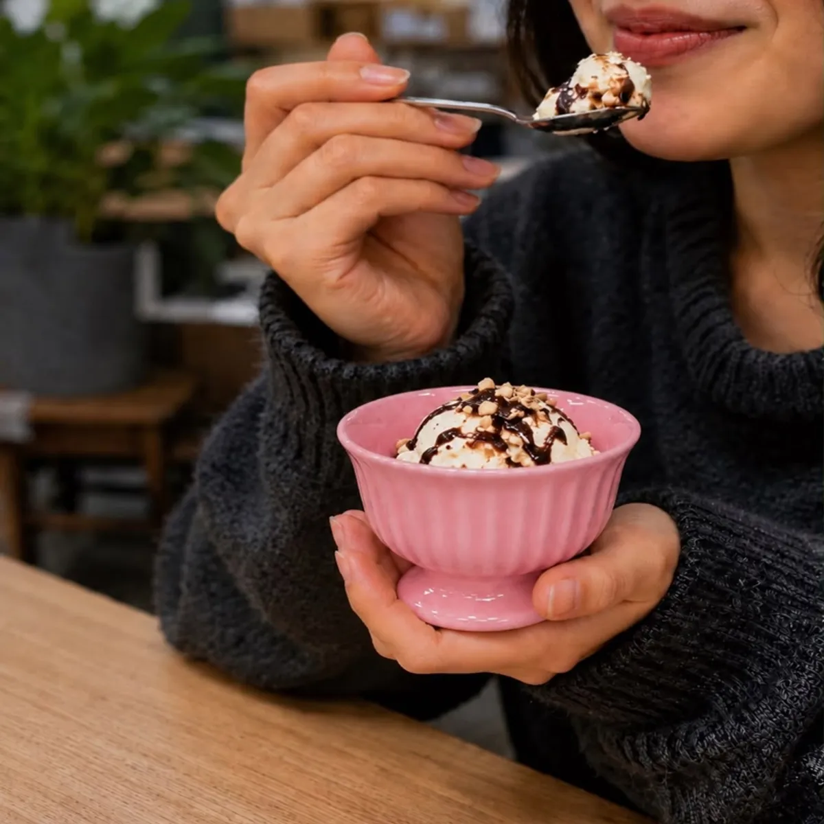 Person holding a pink footed dessert cup filled with ice cream