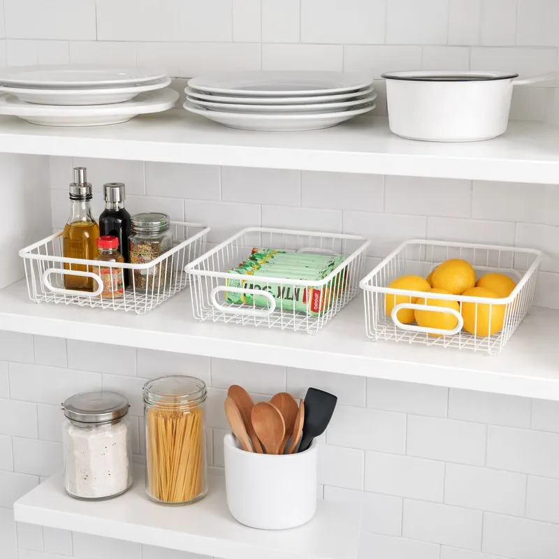White wire baskets arranged on open kitchen shelves with pantry items