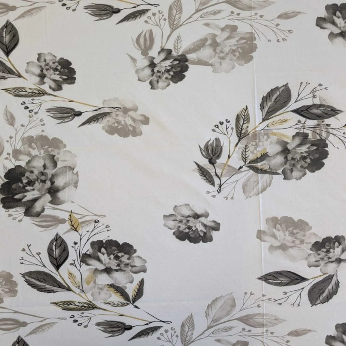 White bedsheet displaying scattered grey and black floral bouquets