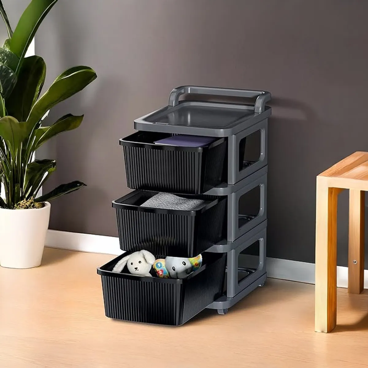 Black and grey storage rack with drawers shown against a dark wall