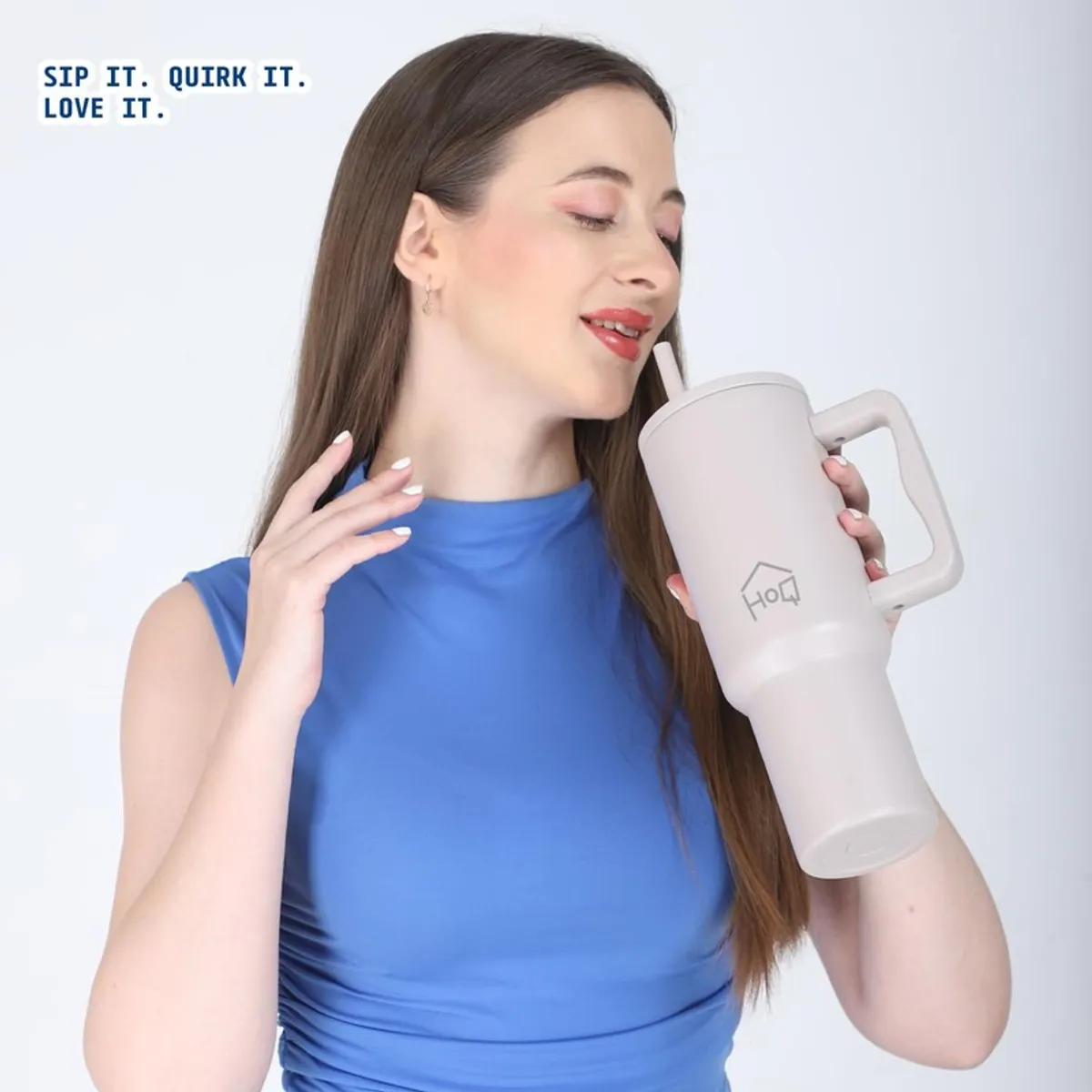 Woman sipping from an oat beige tumbler with handle and straw