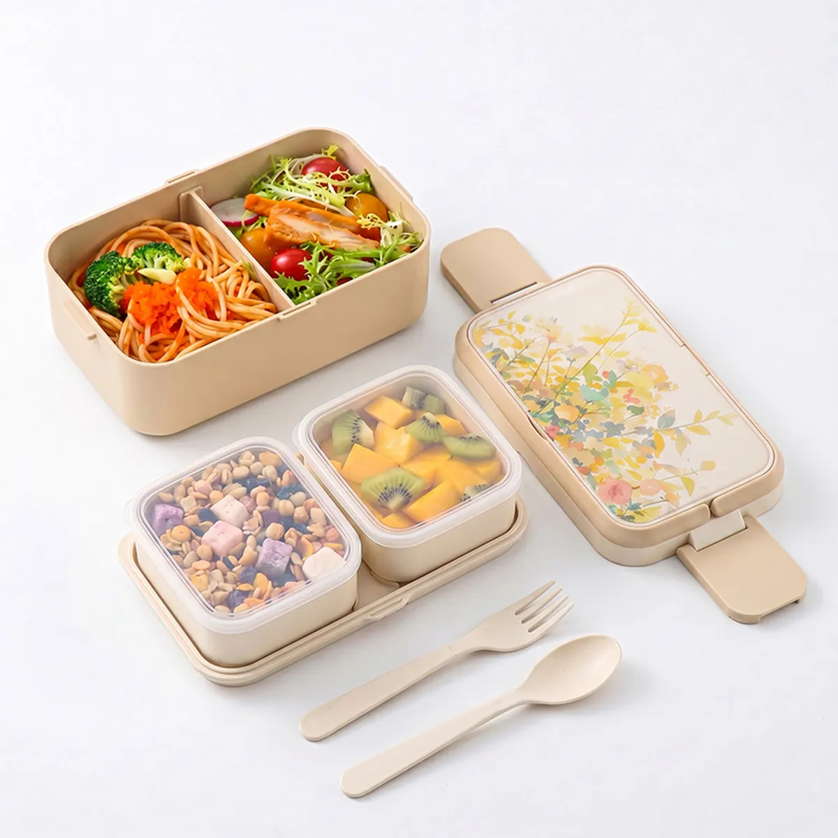 Open beige floral lunch box showing divided meal compartments and cutlery