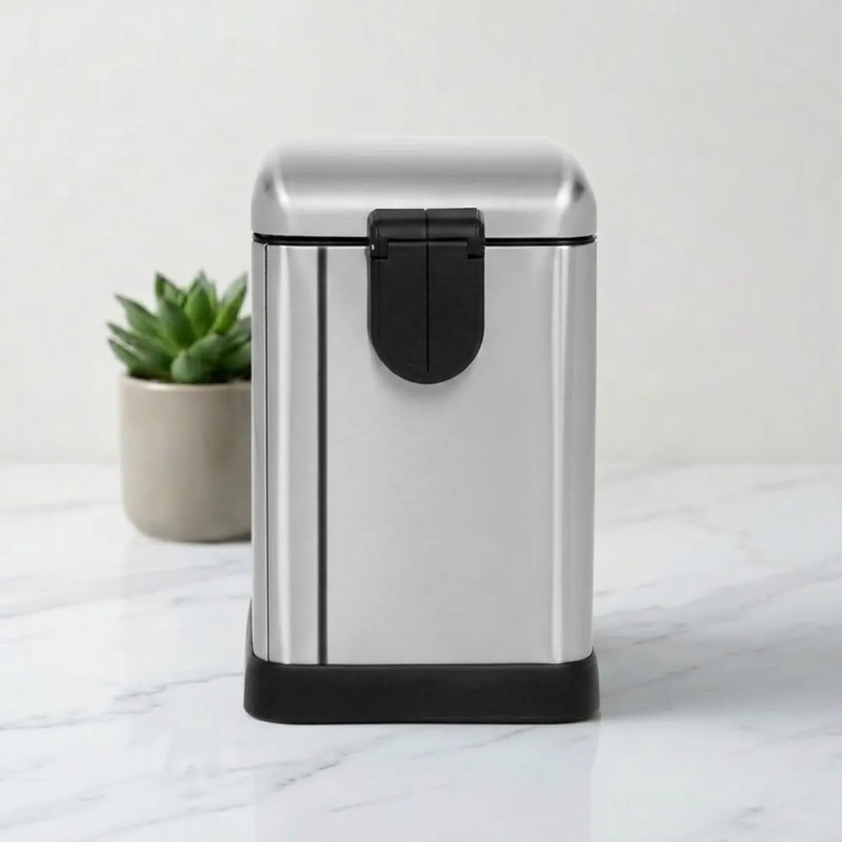 Rear view of a silver metal dustbin with black base