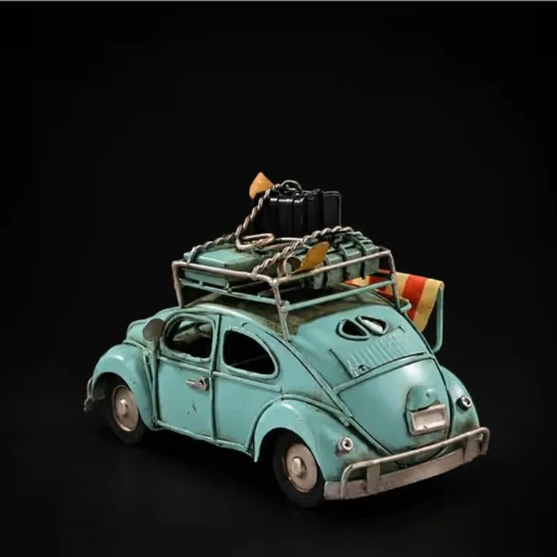 Blue vintage beetle car showpiece with luggage on a black background