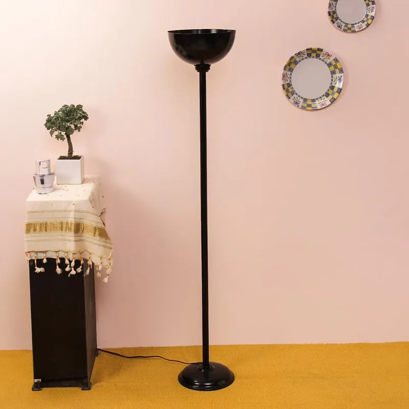 Black uplight floor lamp in a styled room with a pedestal table