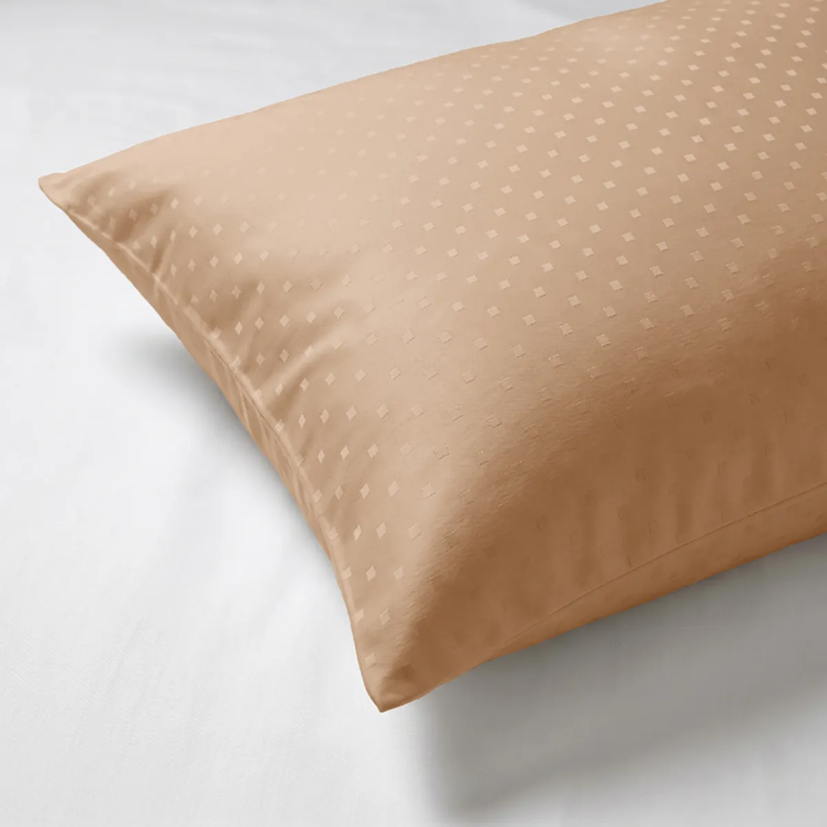 Close-up of an almond pillow cover with a subtle raised dot pattern