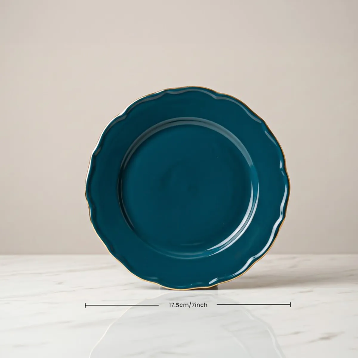 Front view of a dark teal round plate with a gold rim