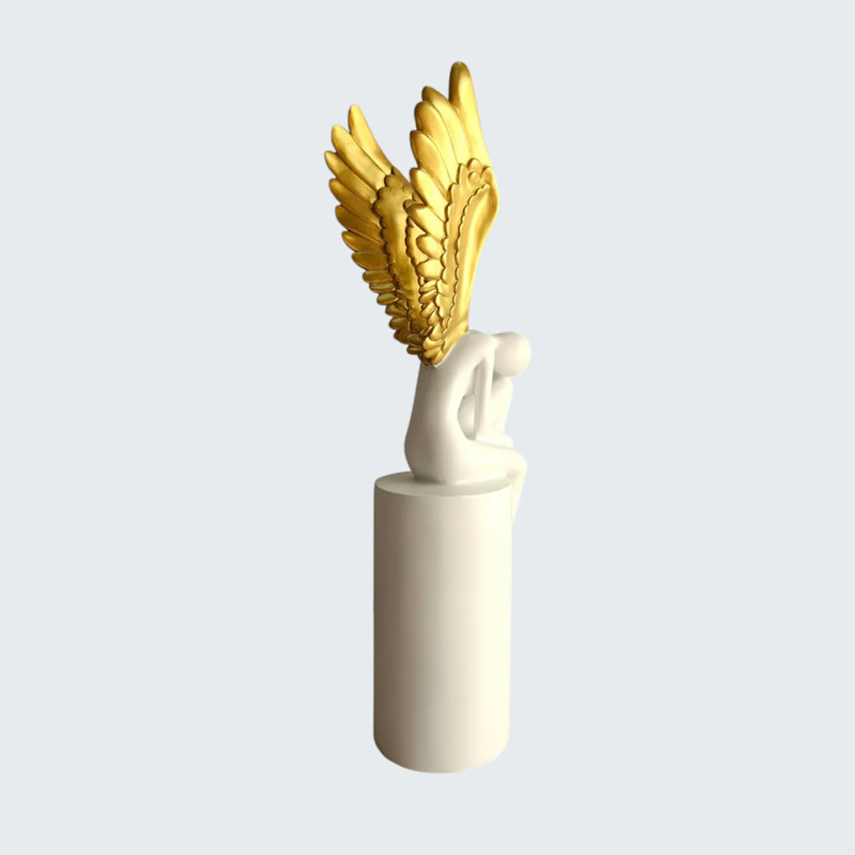 Rear three-quarter view of a white and gold winged figurine on a pedestal