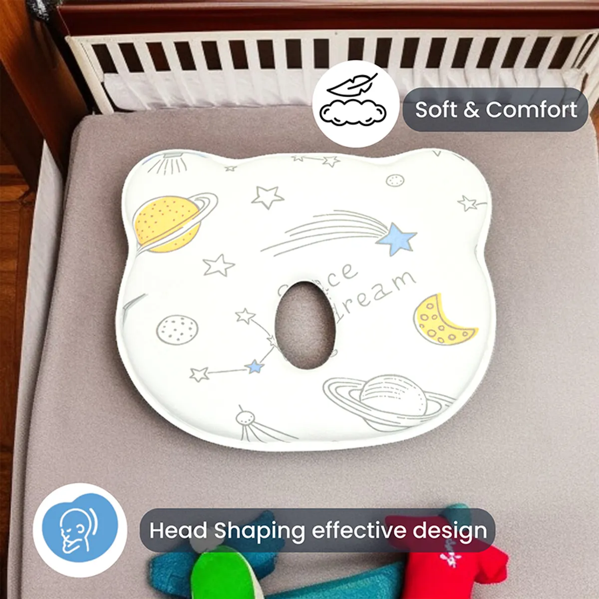 Space-print baby pillow with central cutout on a cot mattress